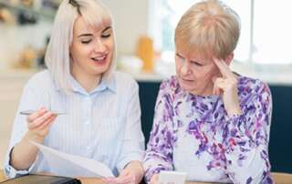 younger woman explaining documents to elder woman